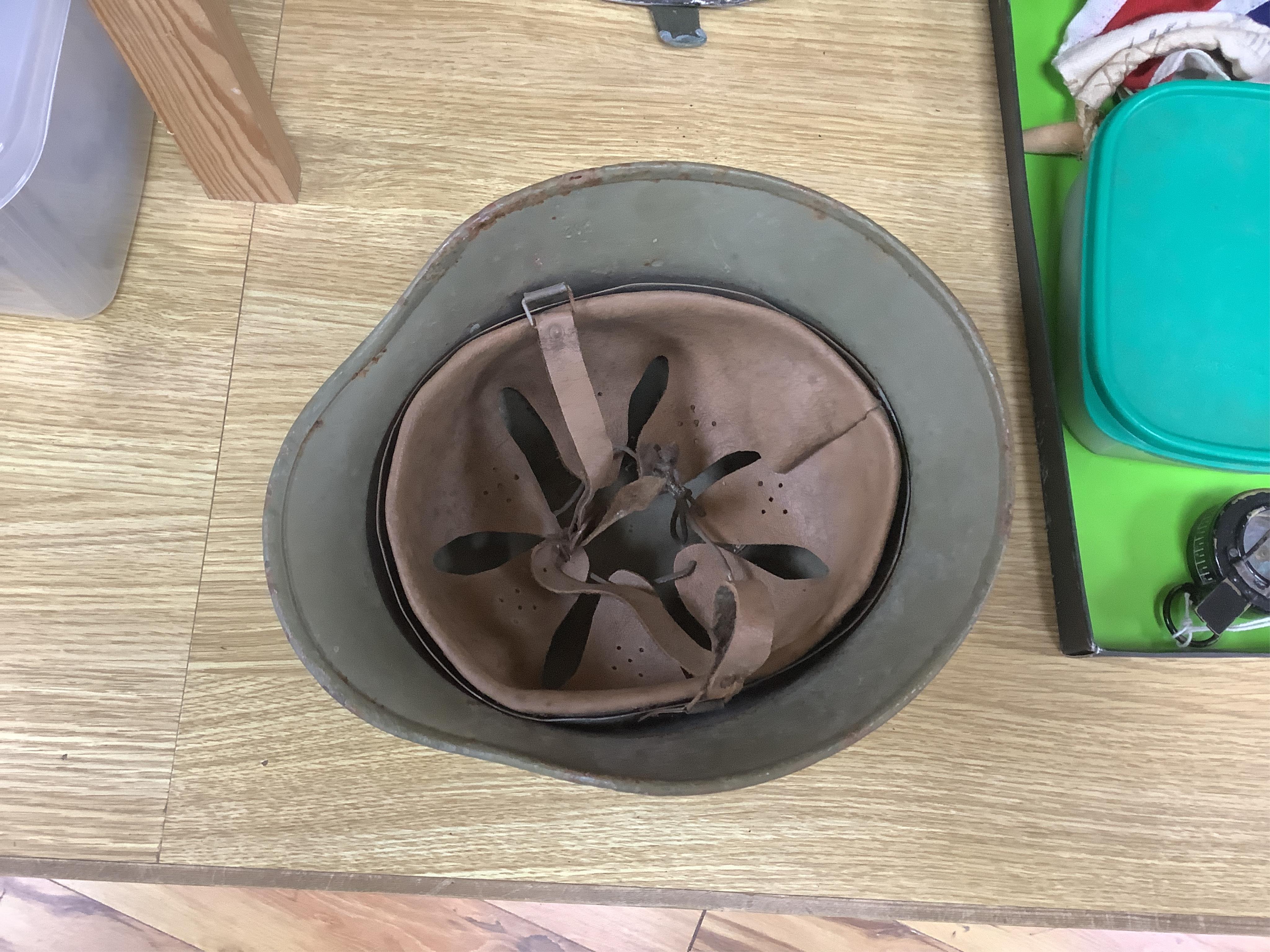 A collection of military items, including a U.S. Army helmet, an M42 helmet, a WWII British Home Front helmet, a Union flag 96cm x 60cm, a compass, a Kukri display shield, and a box of military cap badges, buttons, etc.
